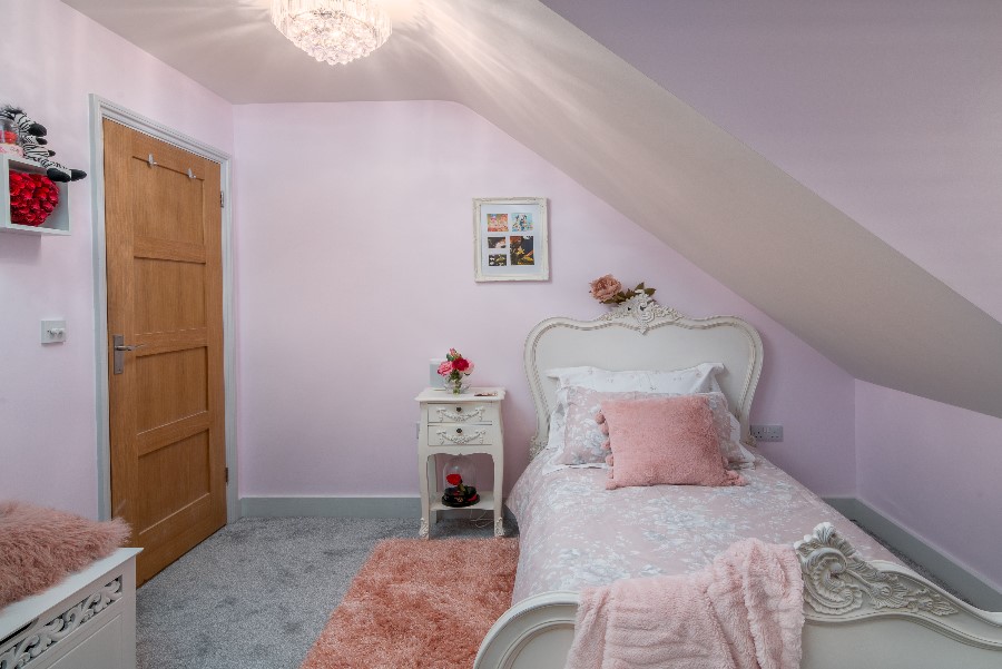 Girls bedroom with ornate white French single bed, crystal chandelier, lilac walls, pink shag rug and white French bedside table — children's interior design Princes Risborough Buckinghamshire